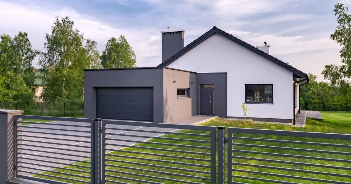 This scene from Lakewood, CO shows a white house with a fence and a fence post. with features such as garage door services garage door repair garage door installation garage door spring repair.