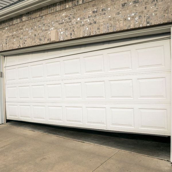This scene from Lakewood, CO shows a white door is open in a brick building. with features such as garage door services garage door repair garage door installation garage door spring repair.