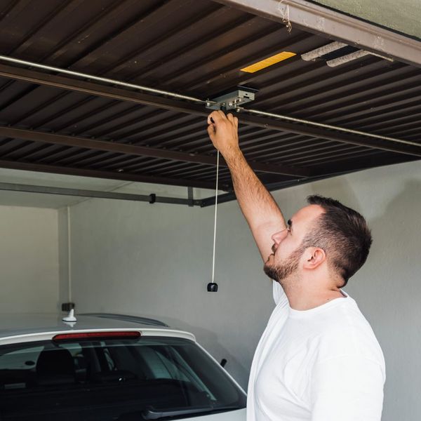 A man holding a tennis racket in his hand. showcasing features like garage door services garage door repair garage door installation garage door spring repair.
