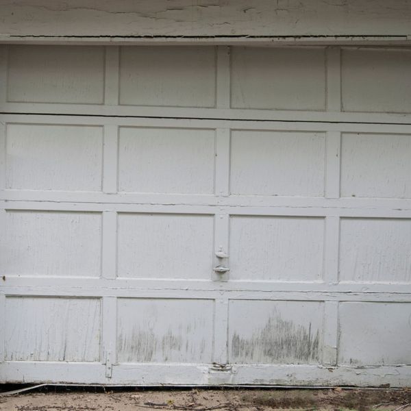 A woman standing in front of a building. showcasing features like garage door services garage door repair garage door installation.
