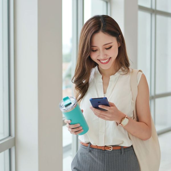 a woman holding a cell phone in her hand. features garage door services garage door repair garage door installation garage door spring repair provided by Retrak Door Service.