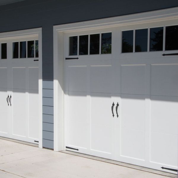 a white door leading to a building with a blue door. features garage door services garage door repair garage door installation garage door spring repair new garage doors provided by Retrak Door Service.